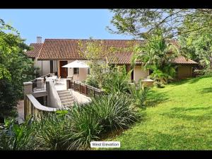 a house with a patio and a yard at 13 Yellowwood - with back-up power in Ballito