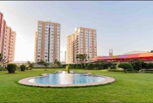 un piccolo stagno in mezzo a un parco con edifici alti di Enzi Apartment Block A-1007 a Nairobi