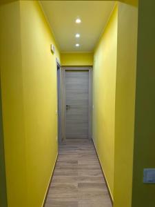 a hallway with yellow walls and a door at Garçonnière Casa Caterina in Ischia