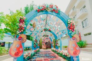 an arch with flowers in front of a building at BANMALI PALACE in Kantābānji