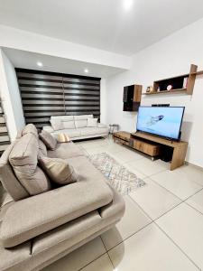 Una sala de estar con un sofá y un televisor de pantalla plana. en Starlight - Kaymakli, en Lefkosa Turk