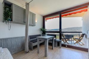a living room with a table and a balcony at Le Chamois - Au pied des Pistes in Villard-de-Lans +77 photos