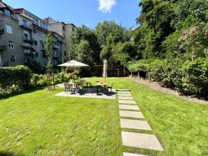 ogród ze stołem, krzesłami i parasolem w obiekcie Beletage Luxury Apartments Graz w Grazu