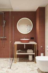 a bathroom with a sink and a mirror at Flesslers Lenggries, a Tribute Portfolio Hotel in Lenggries