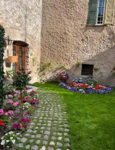 a stone walkway in front of a building with flowers at Il Giardino Segreto in Anagni
