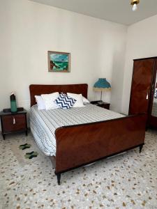 a bedroom with a large bed with a wooden frame at Casa Nicola - Welchome in San Vito Chietino
