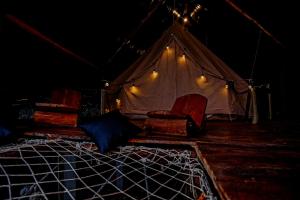 Una habitación con dos sillas y una tienda de campaña. en Ella Soul Nest Glamping Tent for Nature Lovers, en Ella