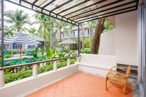 a balcony with a chair and a view of a pool at Signature Phuket Resort in Chalong 