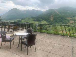 a table and chairs on a balcony with a view of mountains at Ibon de Anayet in Formigal