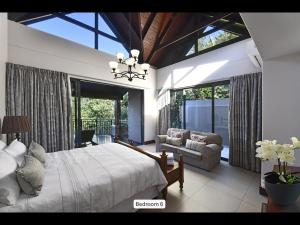 a bedroom with a bed and a large window at 13 Yellowwood - with back-up power in Ballito +38 photos