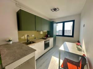 a kitchen with green cabinets and a sink at Nucleo Pipera in Voluntari