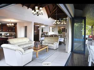 a living room with two couches and a table at 13 Yellowwood - with back-up power in Ballito