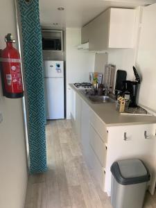 a small kitchen with a sink and a refrigerator at Mobilhome 6pers Camping le Neptune Argeles sur mer in Argelès-sur-Mer