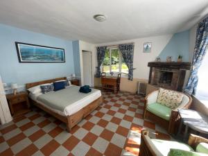 ein Schlafzimmer mit einem Bett und einem Stuhl und einem Kamin in der Unterkunft Le Moulin L'Eveque in Campeaux