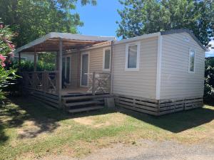 a tiny house with a porch and a deck at Mobilhome 6pers Camping le Neptune Argeles sur mer in Argelès-sur-Mer