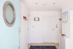 a white bathroom with a mirror on the wall at 3-Bed Beach Bungalow & Garden 150m to Sea in West Wittering