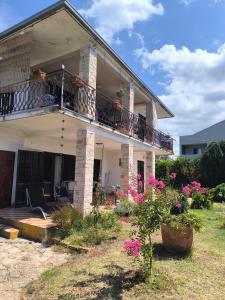a house with a balcony and flowers in the yard at Apartments Ribić in Umag