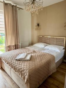 una camera da letto con un grande letto e un asciugamano di Apartamenty Ku Słońcu - Kuracyjna - Jastrzębia Gora a Jastrzębia Góra