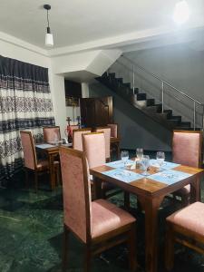 a dining room with tables and chairs and a staircase at Bluebell hotel and family restaurant in Sri Jayewardenepura Kotte