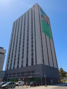 Un edificio alto con un cartel al costado. en Silesian Gold Apartments, en Katowice