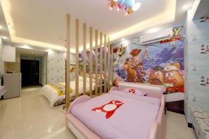 a bedroom with two beds and a wall with mickey mouse mural at Xingyue Apartment Nimble Huamei Branch in Guangzhou