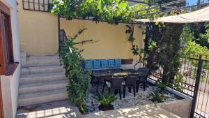 a patio with a table and chairs in a garden at Sunset Villa in Bar