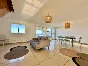 a living room with a couch and a table at Whale- vue unique mer & littoral de Trois-Bassins in Trois Bassins +17 photos