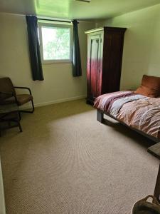 a bedroom with a bed and a window and a chair at Bed & Breakfast Twekkelo in Enschede +23 photos