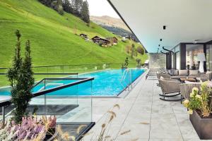 una casa con piscina con una colina verde en Gästehaus Wildschütz, en Tux