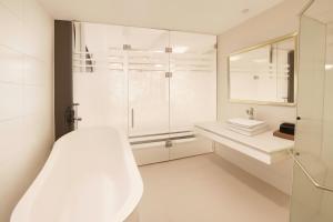 a white bathroom with a shower and a sink at Eco Nest Signature Hotel in Hanoi
