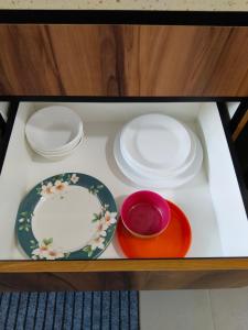 a table with plates and bowls in a drawer at Homestay Pinggiran Kota Kuantan in Kuantan