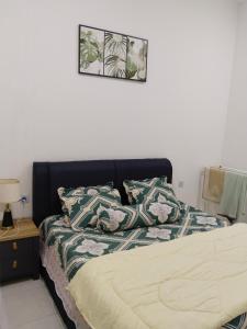 a bed with two pillows on it in a bedroom at Homestay Pinggiran Kota Kuantan in Kuantan