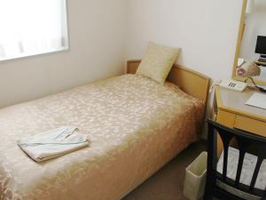 Habitación pequeña con cama, escritorio y escritorio. en Hotel Trend Mito, en Mito