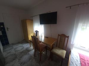 Un comedor con mesa y sillas y un televisor. en Bursztynowy Brzeg, en Gąski