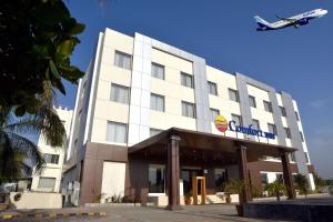 a plane flying over a hotel with a hotel at Comfort Inn Donil Vadodara in Vadodara