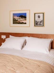 ボーソレイユにあるAlfred Hotels Monaco - ex Forum - Hôtel rénovéの白いベッド2台と壁に2枚の絵が飾られたベッドルーム1室が備わります。 +70枚の写真