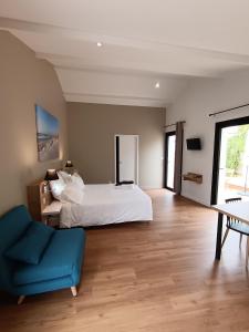 a bedroom with a white bed and a blue chair at Le Logis de Raphabel in Saint-Palais-sur-Mer +54 photos