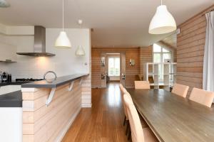 une cuisine et une salle à manger avec une table en bois dans l'établissement The Black House - Luxurious Holiday Villa Zeewolde, à Zeewolde