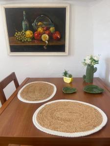 a table with three plates on it with a painting of fruit at Little Troll House 1 in Chrissi Akti
