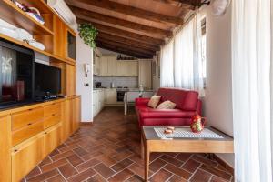 a living room with a red couch and a table at IseoLakeRental - La Colombaia in Monte Isola