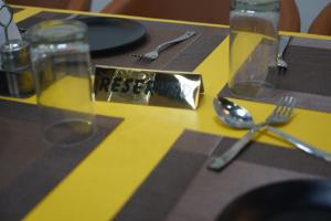 a table with a yellow table with a fork and spoon at Raj Kamal Hotel & Garden in Gwalior