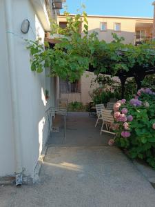 a patio with tables and chairs and flowers at M6 olive tree studio in Sutomore