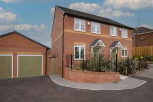 a brick house with a garage in a driveway at Stunning and Bright 3-bed Home in Nottingham by Renzo, Free Parking, Next to M1! in Pinxton