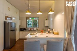 The Poetry House by VEO - Part of StayVista في كارجات: مطبخ مع جزيرة بيضاء كبيرة مع كرسيين