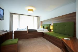 een badkamer met een bed en een wastafel in een kamer bij Das Kronthaler - Adults only in Achenkirch