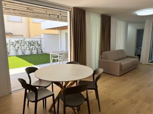 a living room with a table and chairs and a couch at Residenza Harmonia in Lignano Sabbiadoro