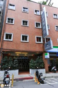 two motorcycles parked in front of a brick building at Red Cabin Inn in Taipei