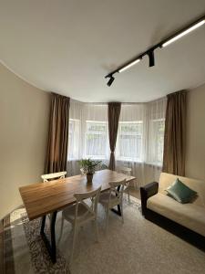 a living room with a wooden table and a couch at Del Hostel in Almaty