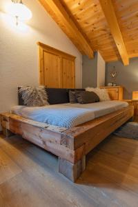 a bed made out of a wooden frame in a room at Kofelhof in Sesto