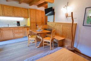 a room with a table and a kitchen with a bed at Kofelhof in Sesto +52 photos